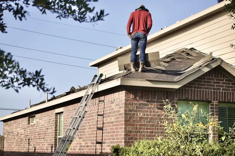 Professional roofer working on a residential roof in British Woods
